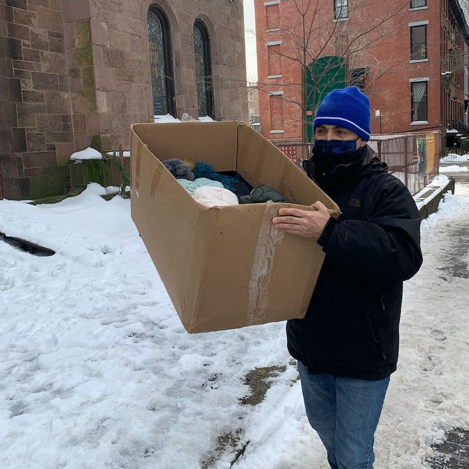 Man carrying box on snow covered sidewalk