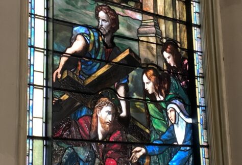 Stained glass window. Scene of Christ with Cross.