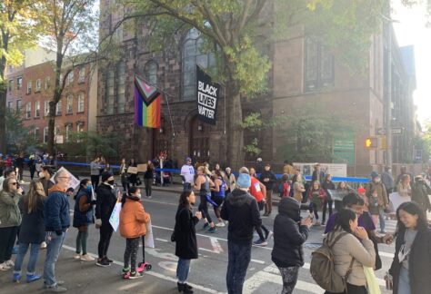 Crowd cheering on runners in the marathon, church in background