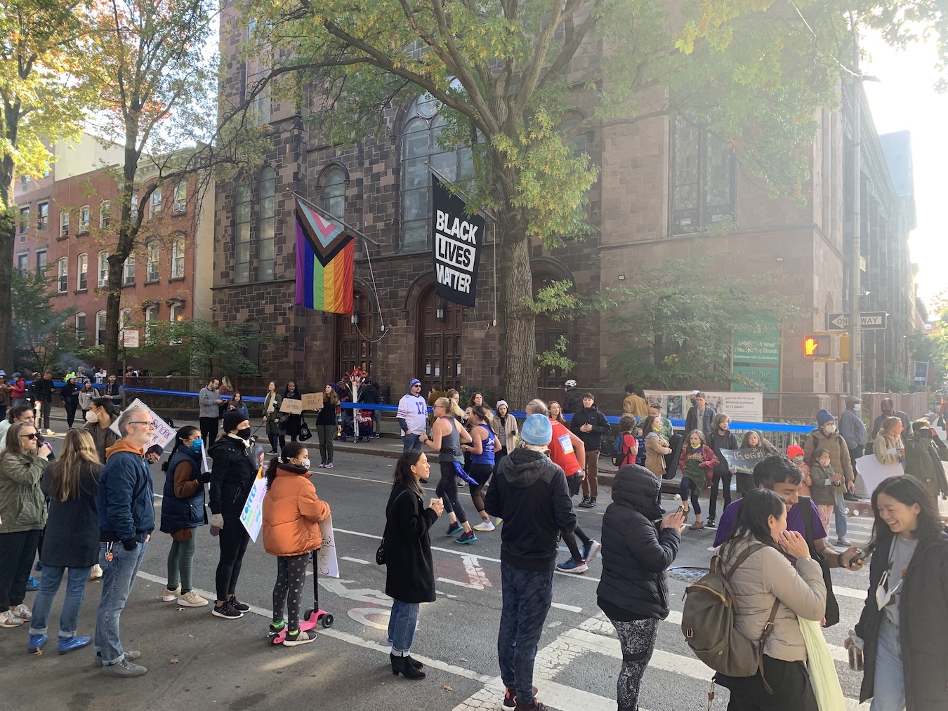 Crowd cheering on runners in the marathon, church in background