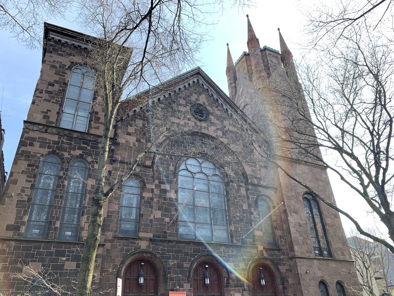 Facade of church building with morning sunlight rainbow flare
