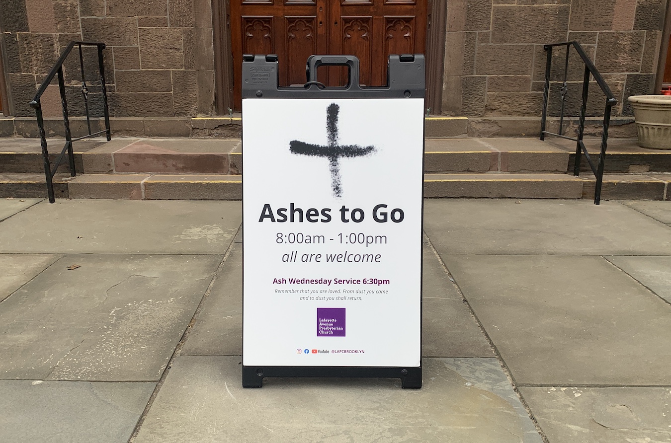 Sign in front of church doors and steps, includes sign of the cross made with ashes, with text Ashes to go, 8am-1pm