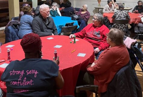 Gathering of people socializing around several large round tables